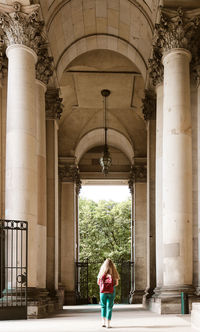 Rear view of teenage girl with backpack walking in corridor