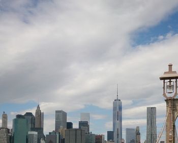 Skyscrapers in city against cloudy sky