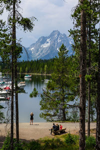 People by lake against mountains