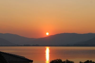 Scenic view of lake against orange sky