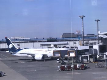 Airplane on airport runway against sky