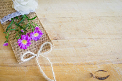 High angle view of flowers on jute over wooden table