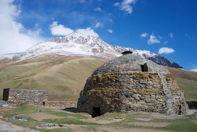 Built structure on rocky mountain against sky