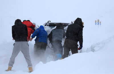 Tourists on snow covered mountain