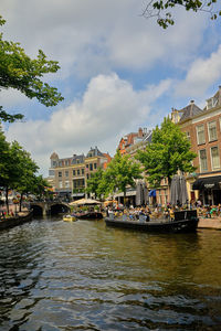 Scenic view of river by buildings against sky