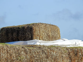 Hay bales on field against sky