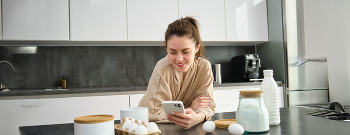 Young woman using phone at home