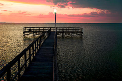 Pier on sea at sunset