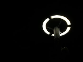 Close-up of illuminated light bulb against black background