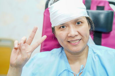 Portrait of female patient showing peace sign