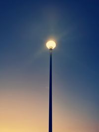 Low angle view of illuminated street light against sky