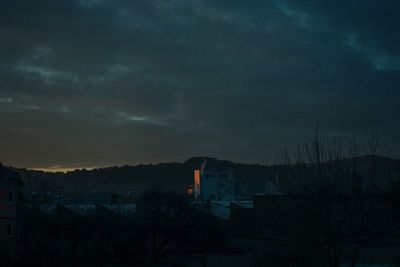 Houses in town against sky during sunset