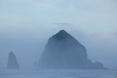 Rock formation in sea against sky