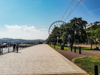 Sidewalk in city against sky