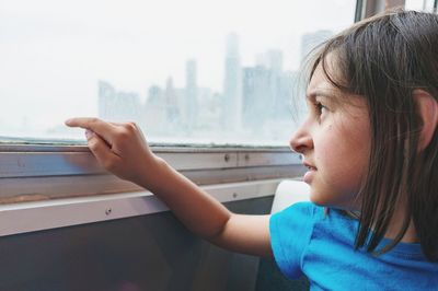 Close-up of girl looking at window in ferry 
