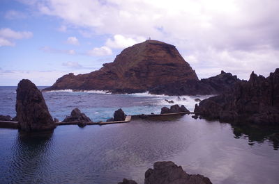 Rock formations in sea against sky