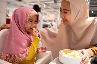 Portrait of smiling young woman having food