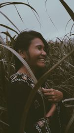 Smiling young woman standing on field