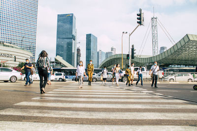 People walking on road against buildings