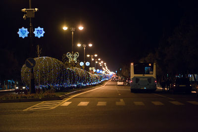 Cars on illuminated street at night