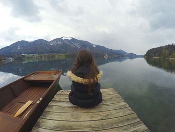 Woman looking at lake against mountain range