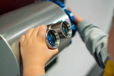 Child's hand holding microscope lens