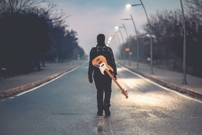 Rear view of man walking on street in city