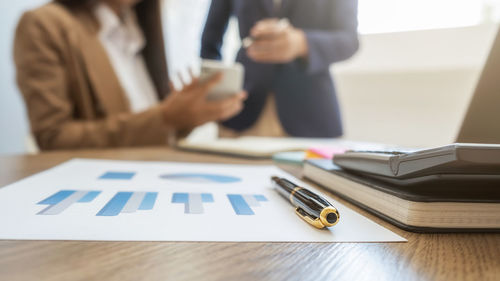 Midsection of businessman working on table