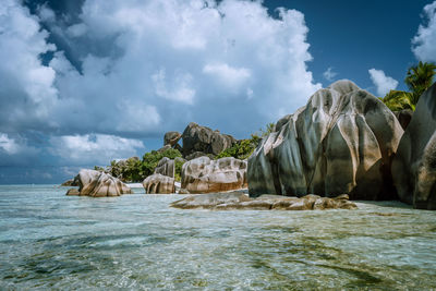 Rocks on sea shore against sky