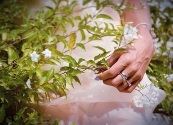 Midsection of woman by blooming flowers