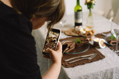 Video blog. a young woman is filming kitchen goods for her online store on her phone camera.