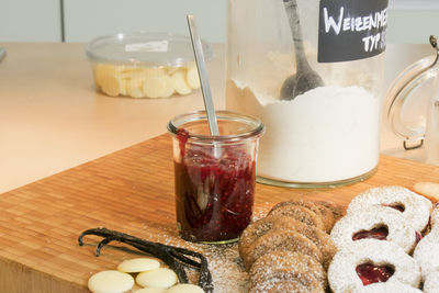 Food ingredients by cookies o cutting board at table