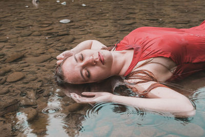 High angle view of woman lying in water