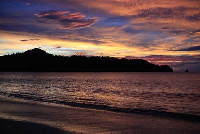 Scenic view of sea against dramatic sky during sunset