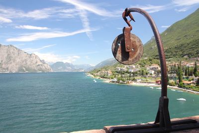 Ferris wheel hanging by sea against sky