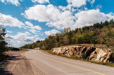 Empty road along trees