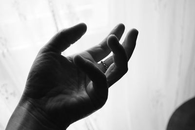 Cropped image of hand gesturing against curtain