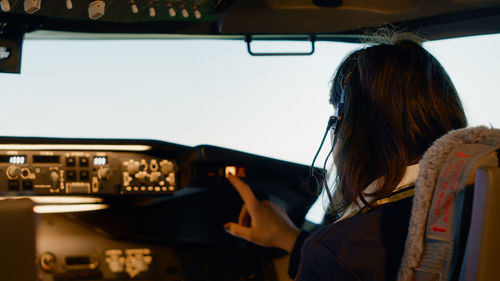 Low angle view of young woman sitting in car