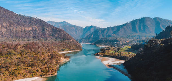 Scenic view of lake by mountains against sky