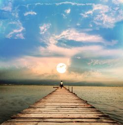 Scenic view of pier over sea against sky during sunset