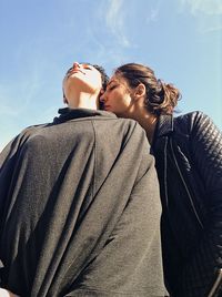 Romantic lesbian couple against sky