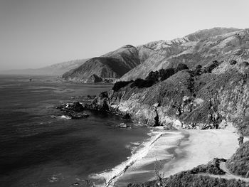 Scenic view of sea and mountains against clear sky