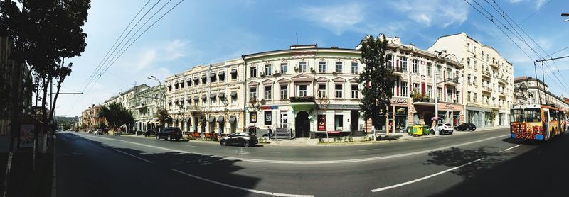 Panoramic view of city street and buildings against sky
