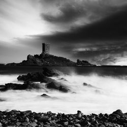 Scenic view of sea by buildings against sky