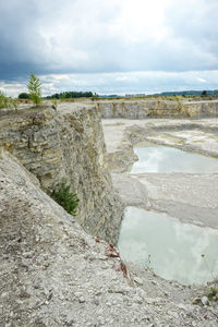 Open-pit mine against cloudy sky