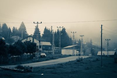 Houses by road against sky during winter