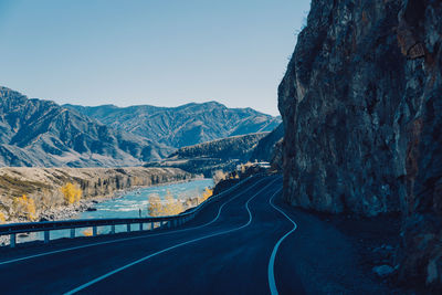 Road amidst mountains against clear sky