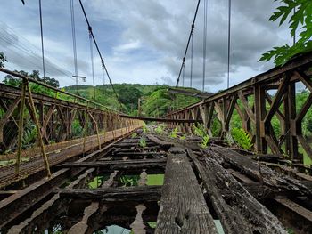 Surface level of abandoned railroad tracks against sky