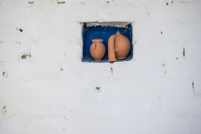 Close-up of clay containers on niche