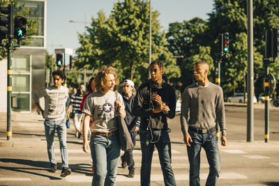 Male friends crossing road in city